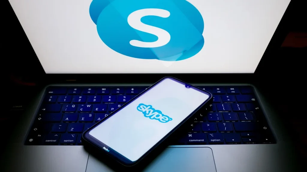 An iPhone and a MacBook showing Skype on the screen