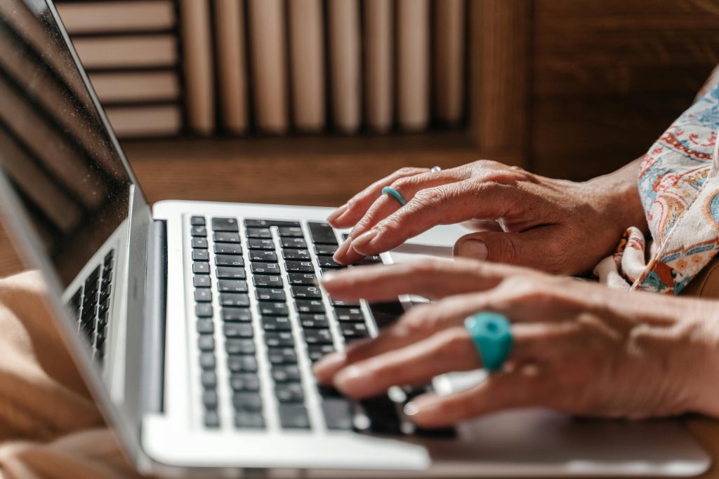 seniors hands typing on a laptop keyboard