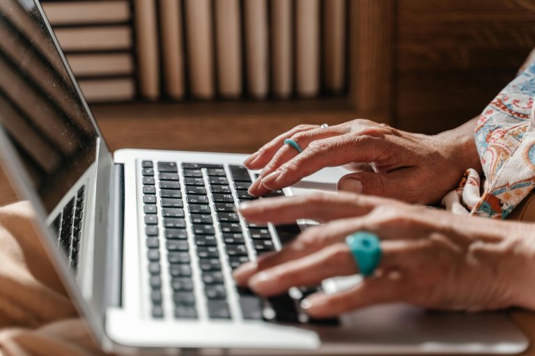 seniors hands typing on a laptop keyboard